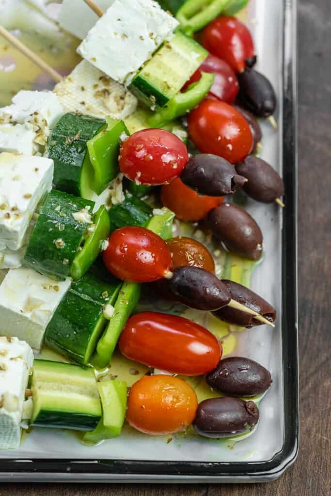 close up of Greek salad kebabs with Greek-style dressing.