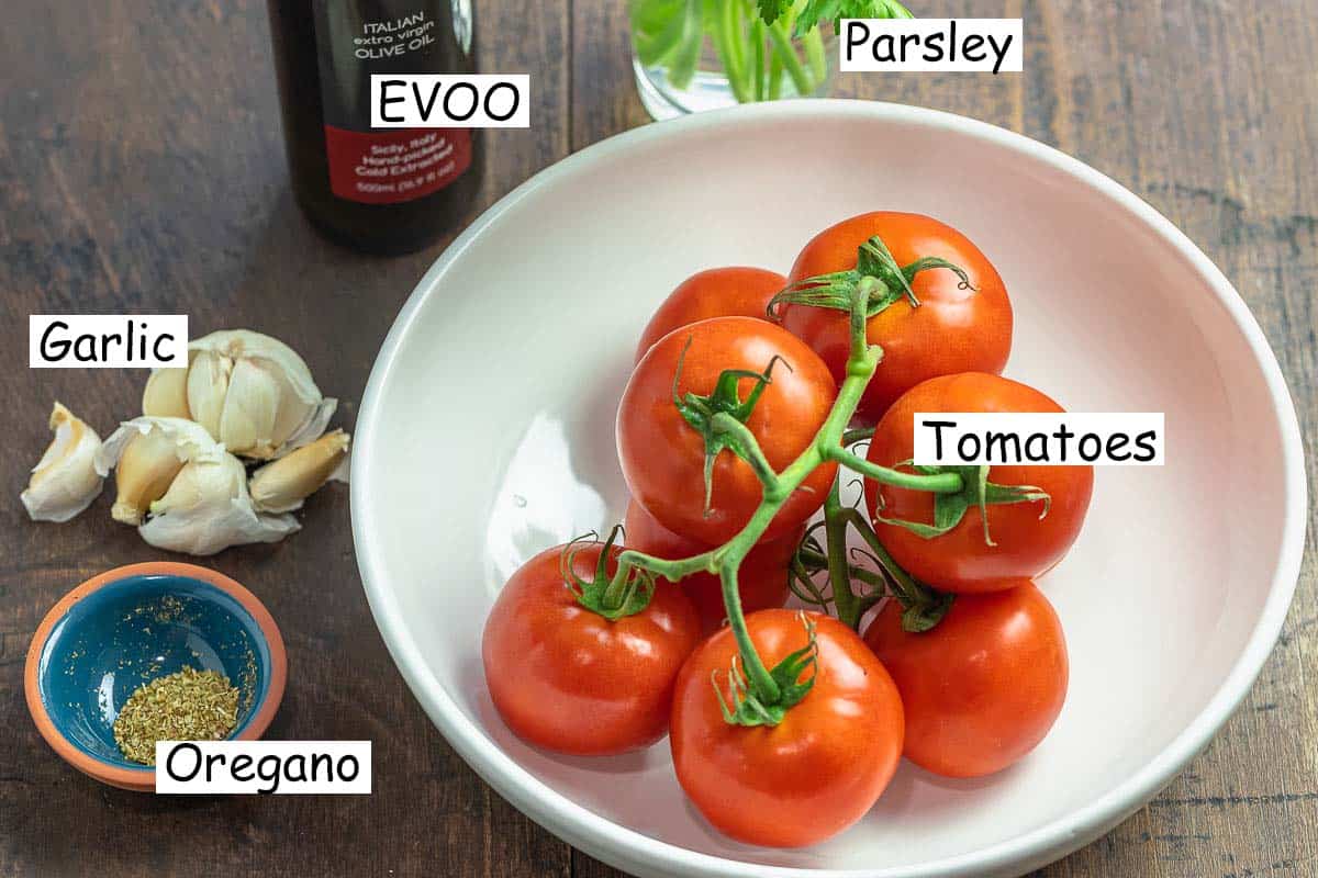 labeled ingredients for no cook tomato sauce including parsley, olive oil, tomatoes, garlic, and oregano.