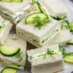 cucumber sandwiches with fresh dill on a plate.