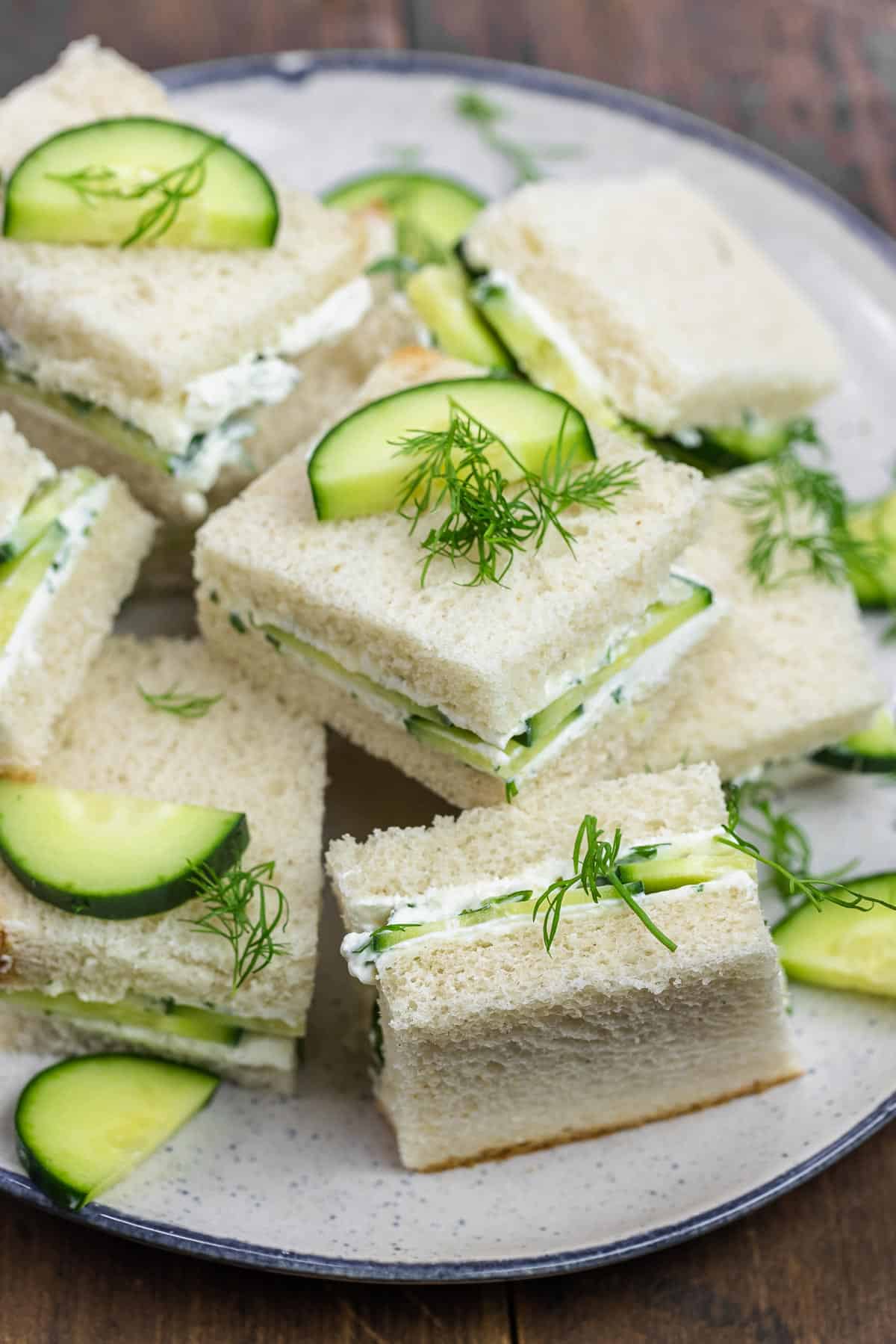 cucumber sandwiches with fresh dill on a plate.
