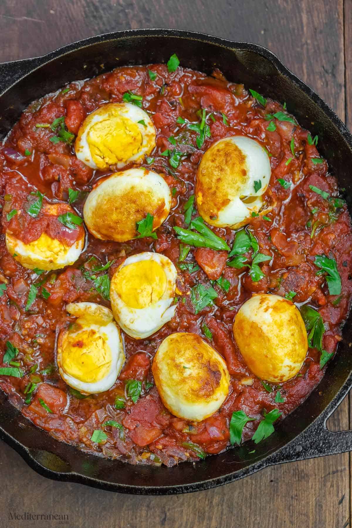 eggs in spicy tomato sauce with a garnish of fresh parsley