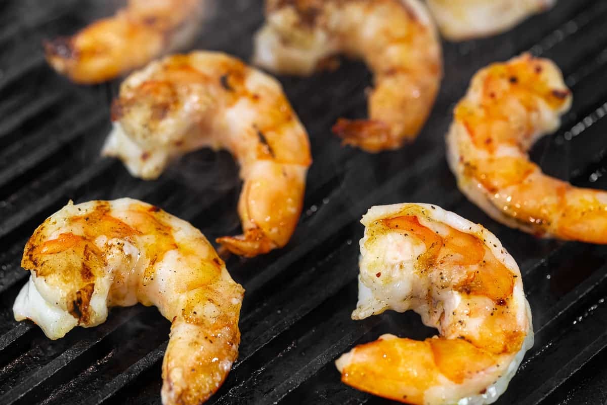 close up of jumbo shrimp cooking on the grill.
