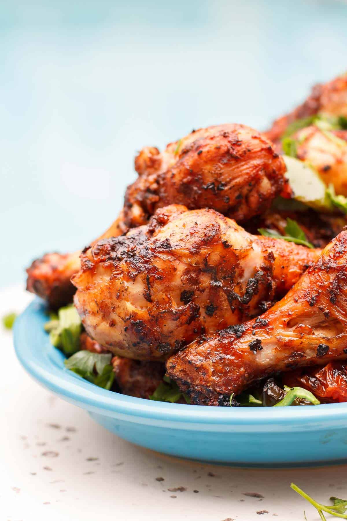 grilled chicken legs in a blow plate. A close up shot.