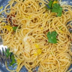 gros plan de pâtes au citron avec du persil frais, du zeste de citron et du parmesan.
