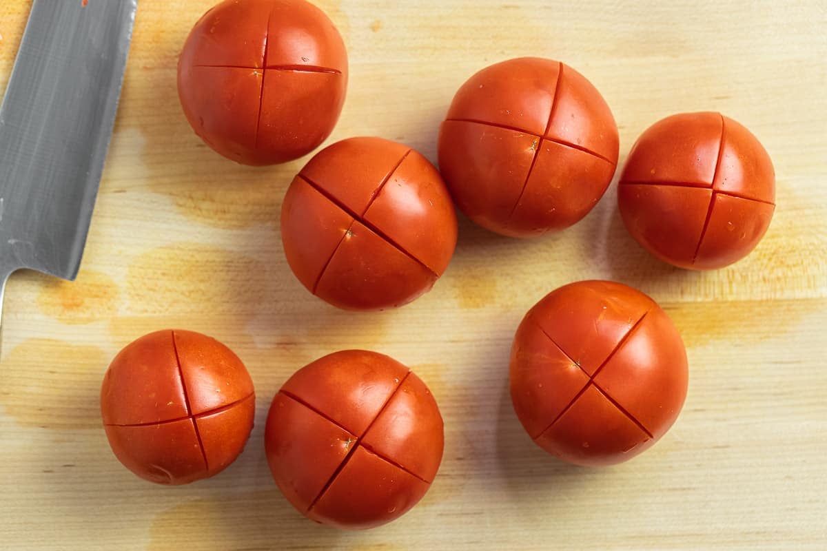 des tomates entières en forme de X coupées en tranches pour faciliter le râpage.