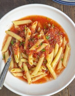 penne and no cook tomato sauce in a white bowl.