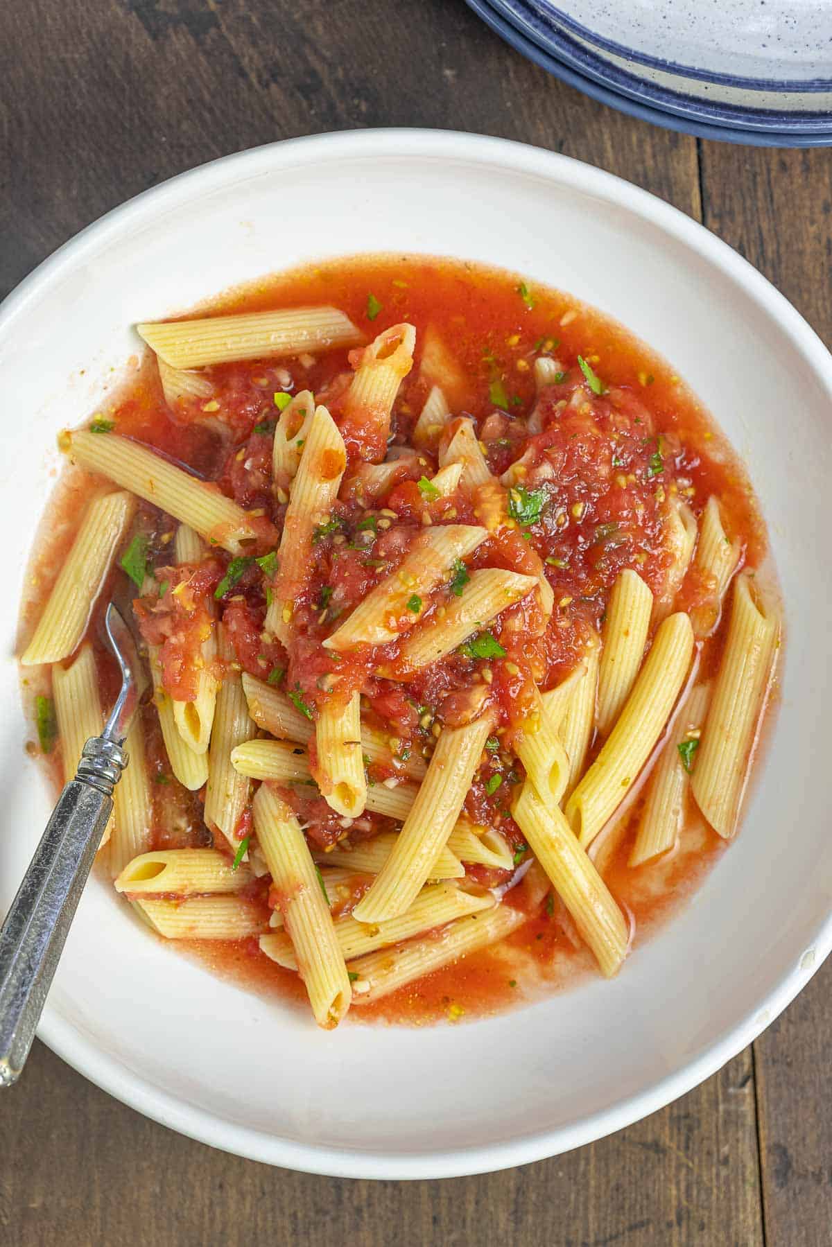penne pasta and no cook tomato sauce in a white bowl.