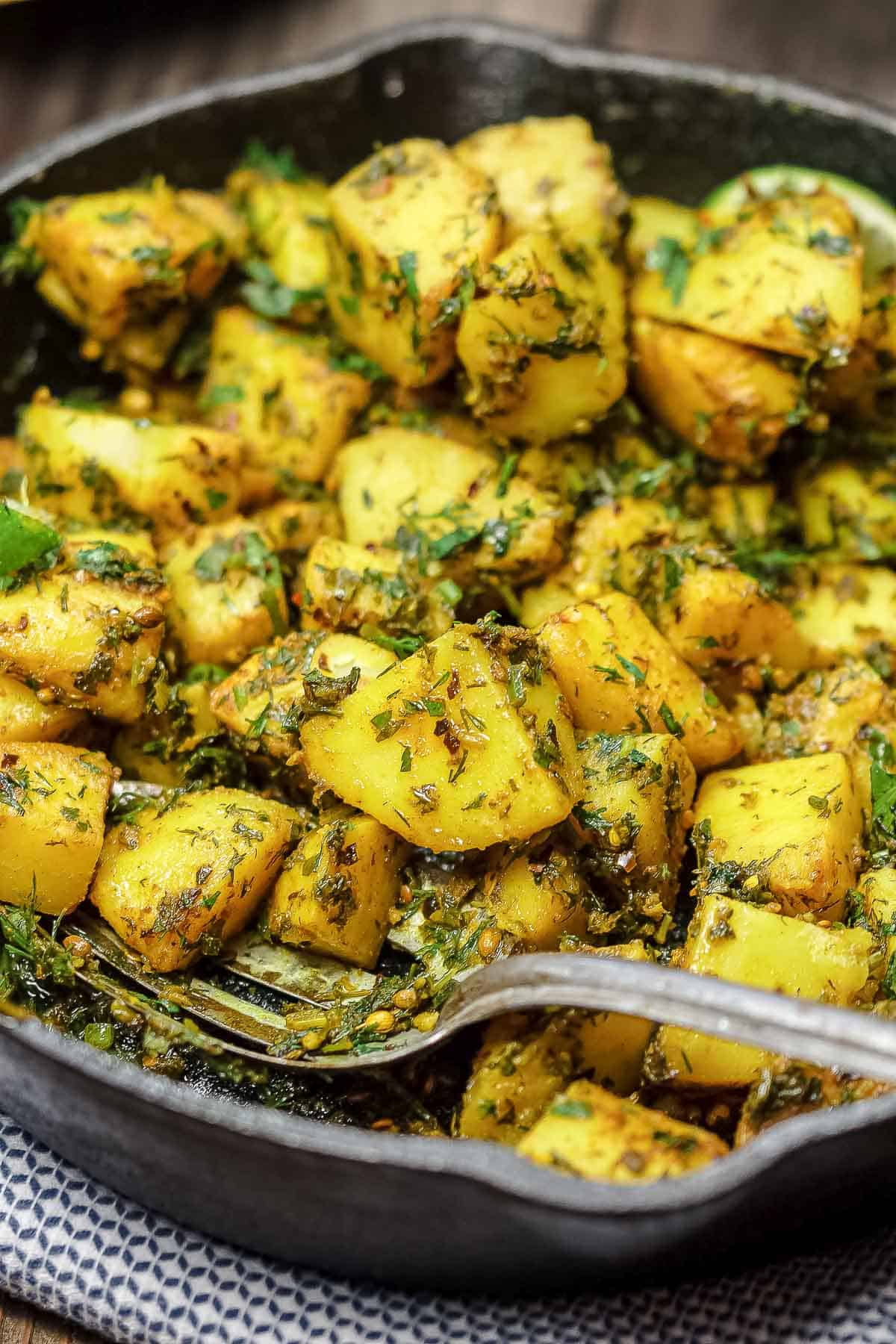 Middle Eastern spicy potatoes in a skillet with spices and herbs.