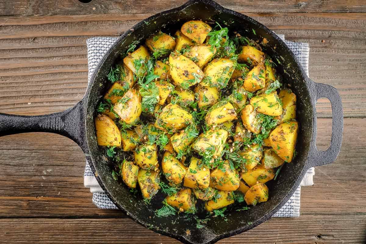 Turmeric potatoes in a cast-iron skillet.