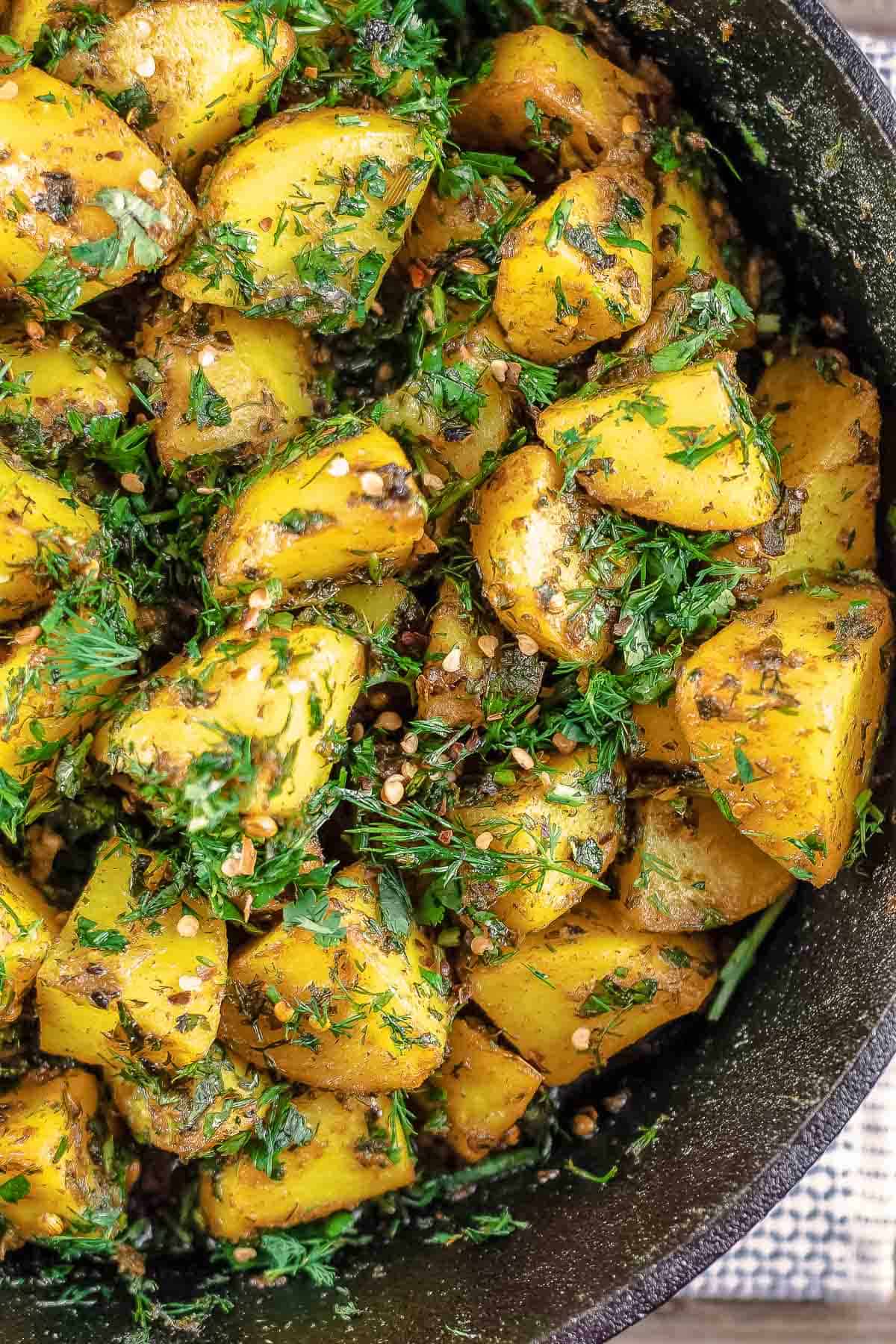 Spicy potatoes with loads of fresh herbs in a cast-iron skillet.