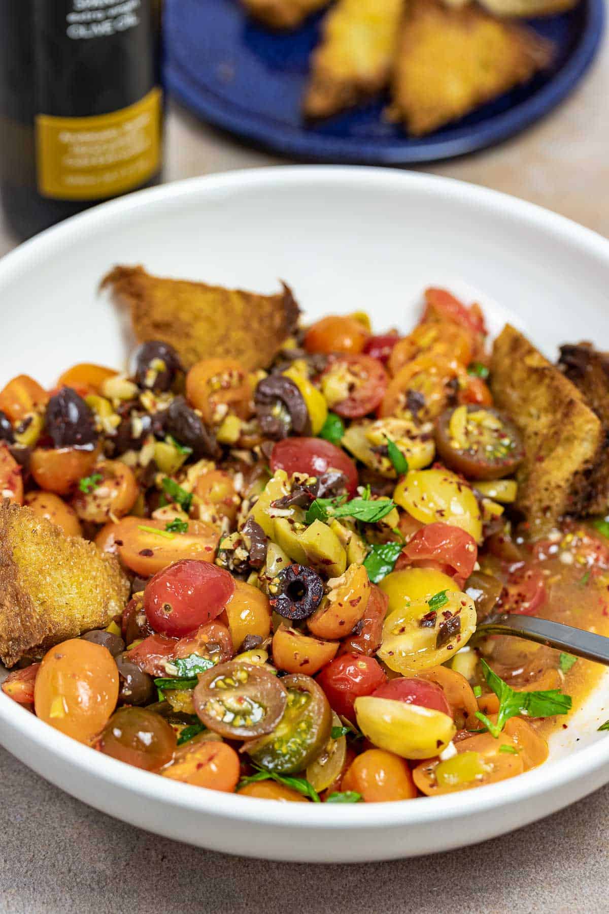 cherry tomato salad on a white plate with fried bread.