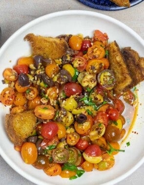 simple cherry tomato salad on a plate with fried sourdough.