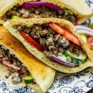 Middle Eastern sandwich in a pita on a blue and white plate.