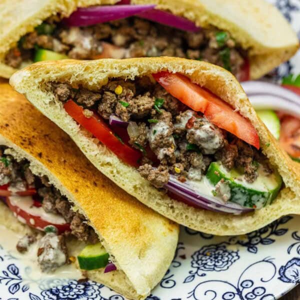 Middle Eastern sandwich in a pita on a blue and white plate.