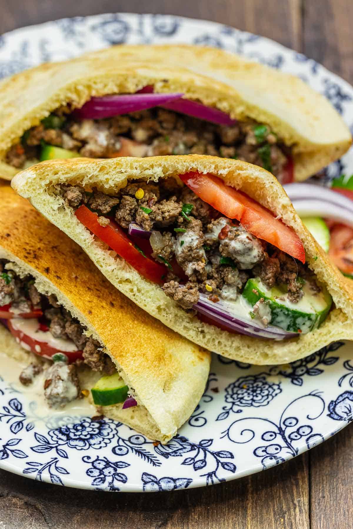 Middle Eastern sandwich in a pita on a blue and white plate.