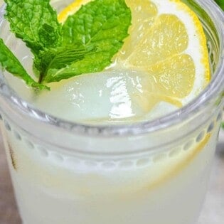 ouzo drink with fresh lemon, ice, and mint leaves.