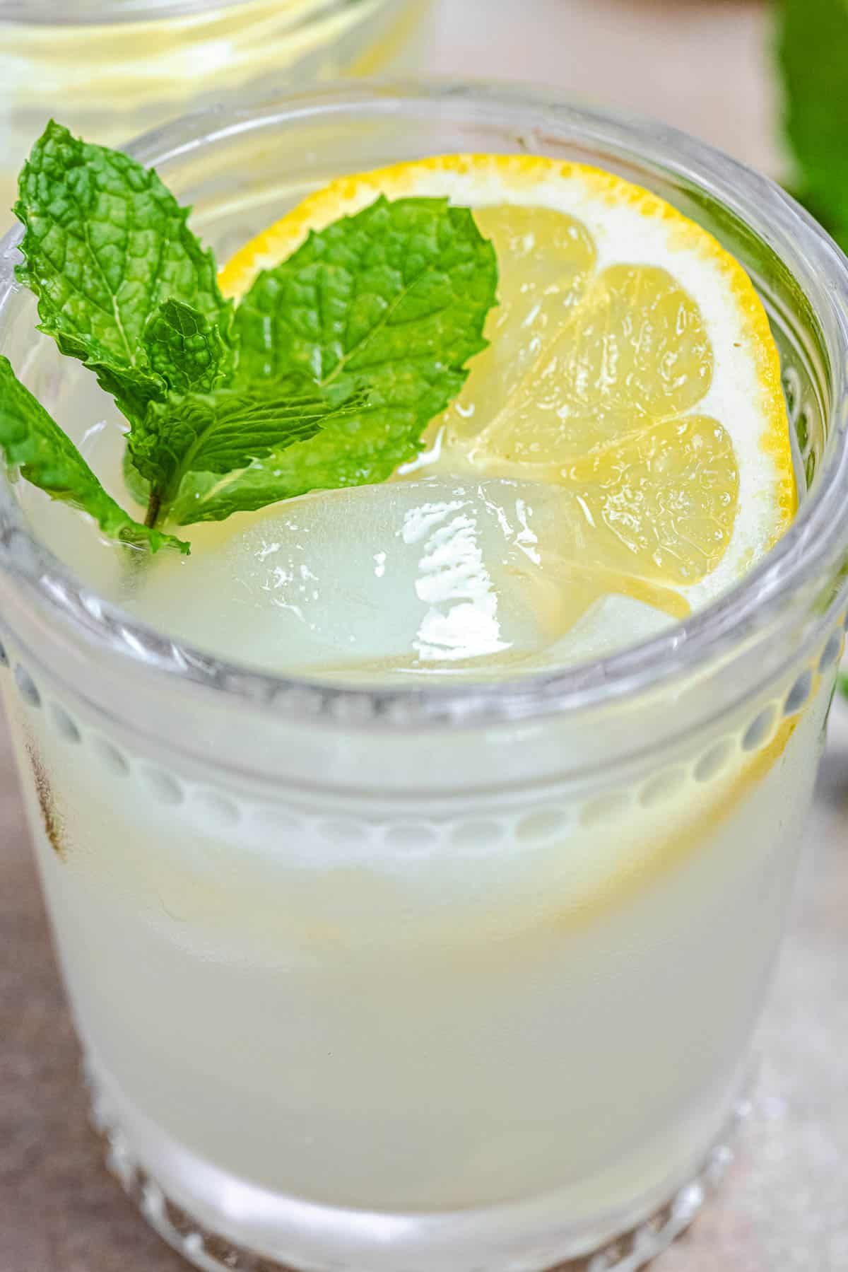 ouzo drink with fresh lemon, ice, and mint leaves.