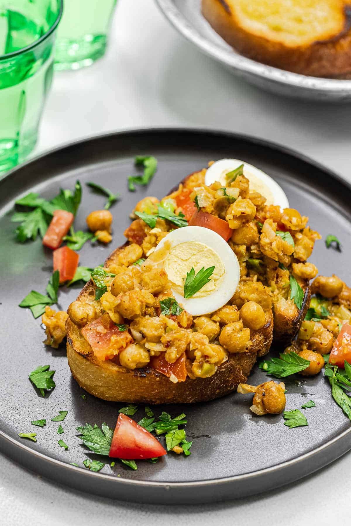 smashed chickpea topping on a slice of toast, topped with slices of boiled egg.