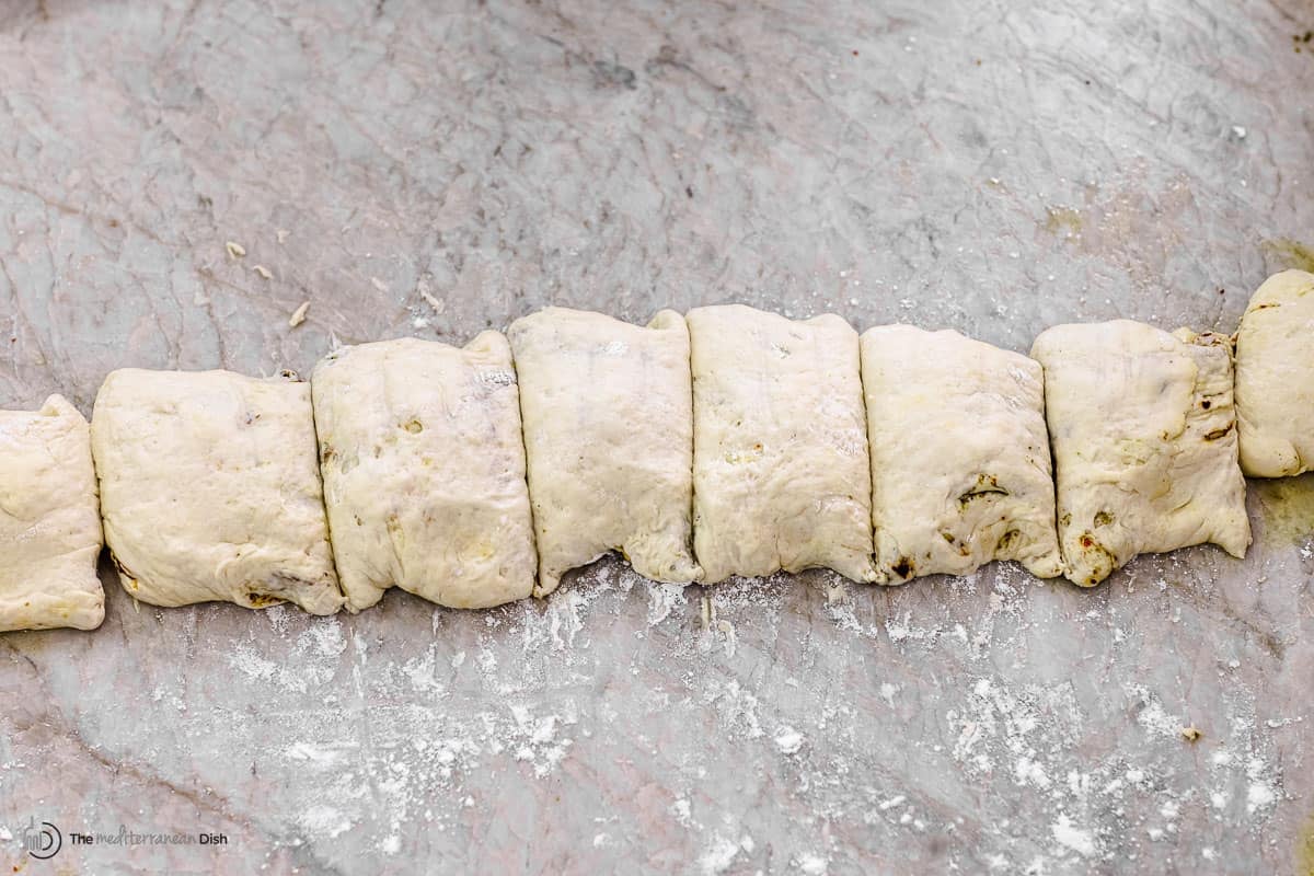 dough rolled into a log and then cut into 9 equal pieces for za'atar rolls.