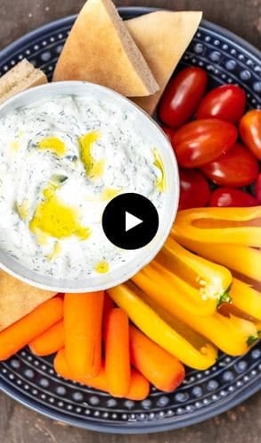 A plate of tzatziki sauce with veggies.