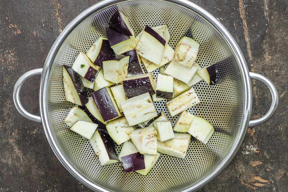 cubed and salted eggplant in a colander.