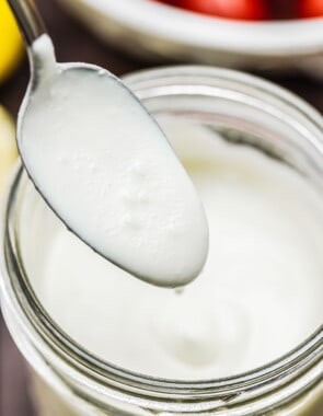 a spoon dipped into feta dressing to show its creaminess.