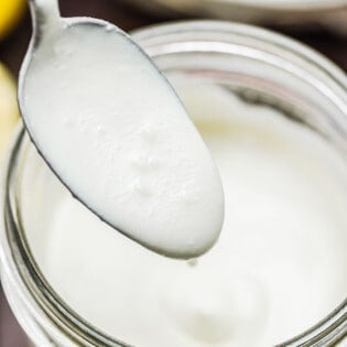 a spoon dipped into feta dressing to show its creaminess.