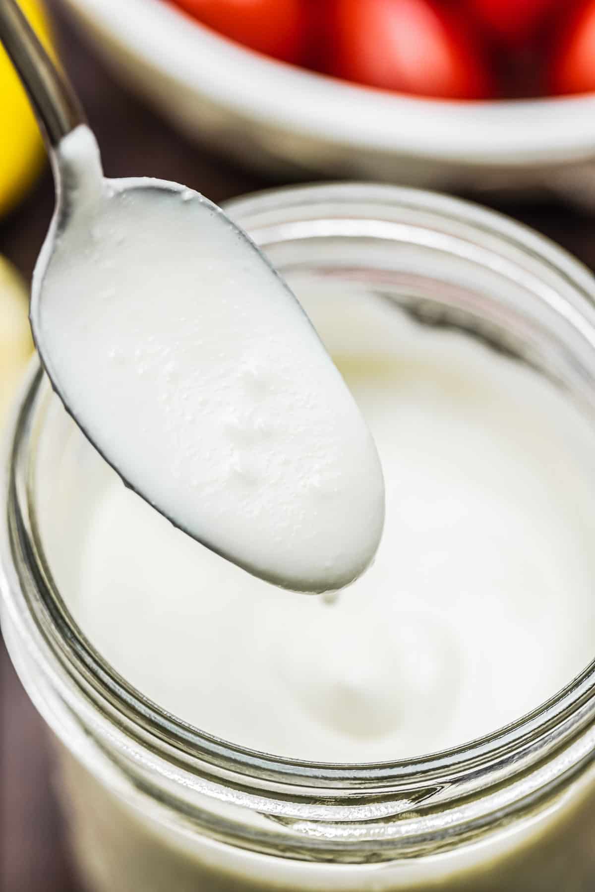 a spoon dipped into feta dressing to show its creaminess.