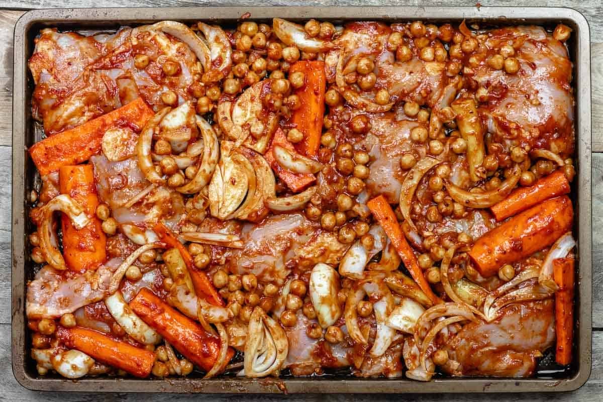 ingredients for sheet pan chicken with chickpeas with the rub added to the sheet pan.