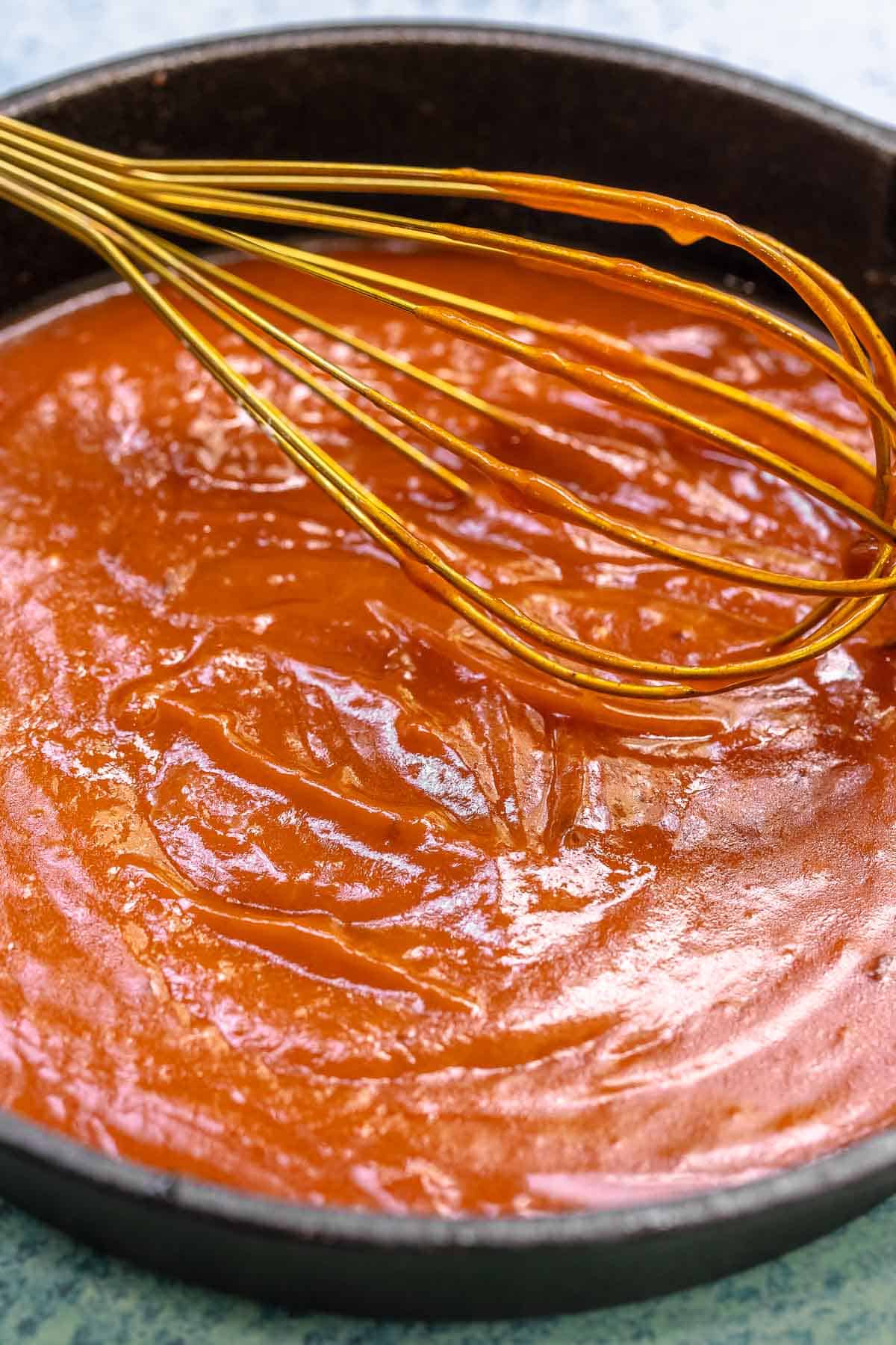 bravas sauce in a pan with a whisk.