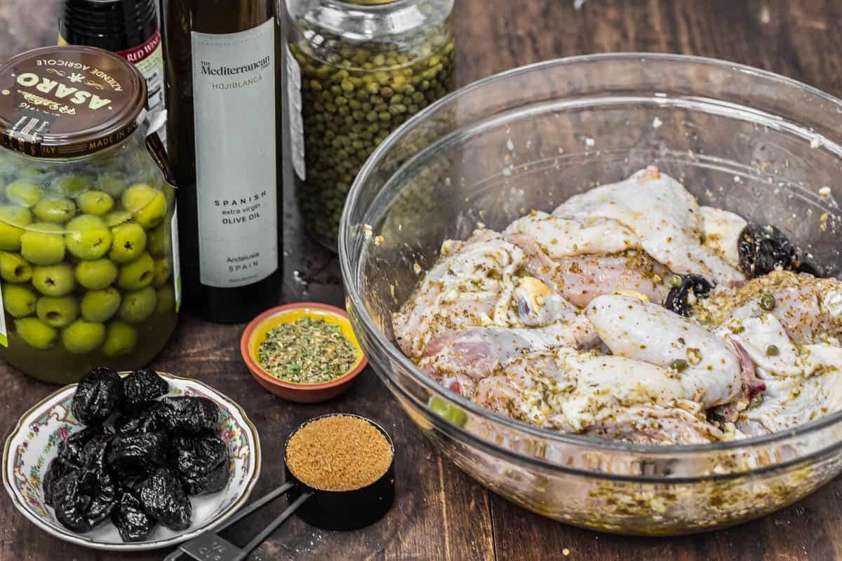ingredients for chicken marbella including EVOO, capers, olives, prunes, and brown sugar.