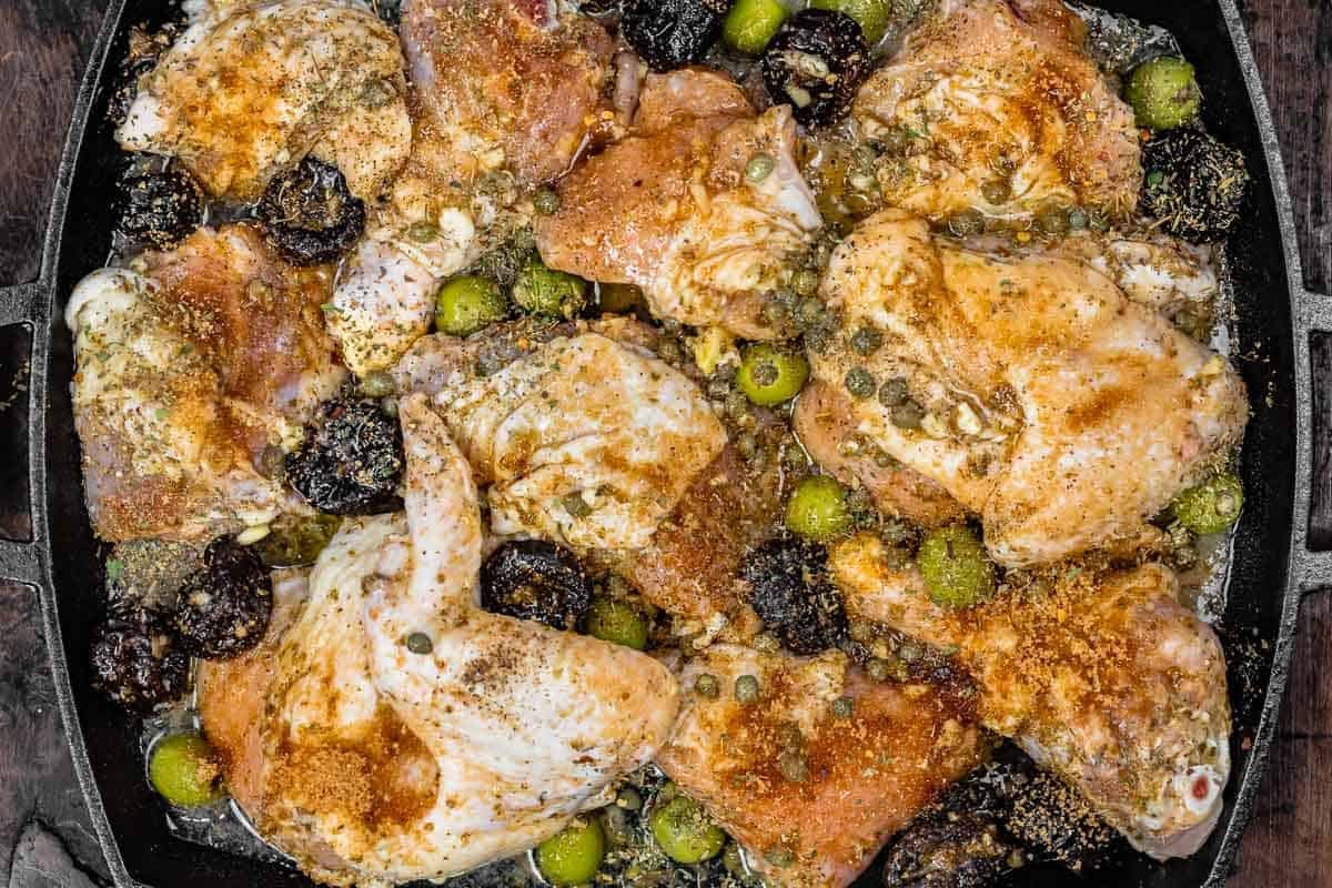 chicken and marinade in a large baking dish ready for roasting.