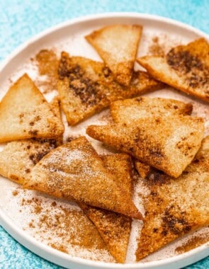 churro chips on a plate dusted with cinnamon and sugar.
