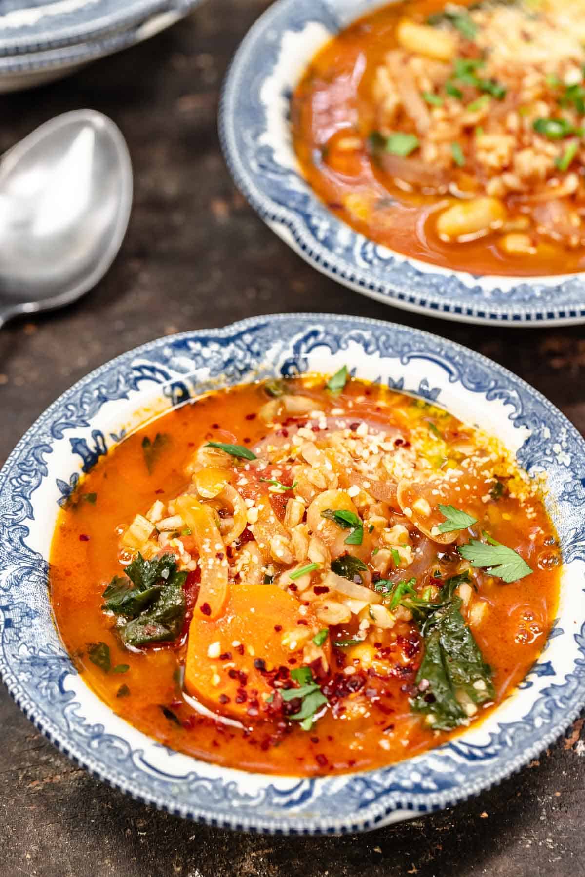 Tuscan farro soup in blue and white bowls.