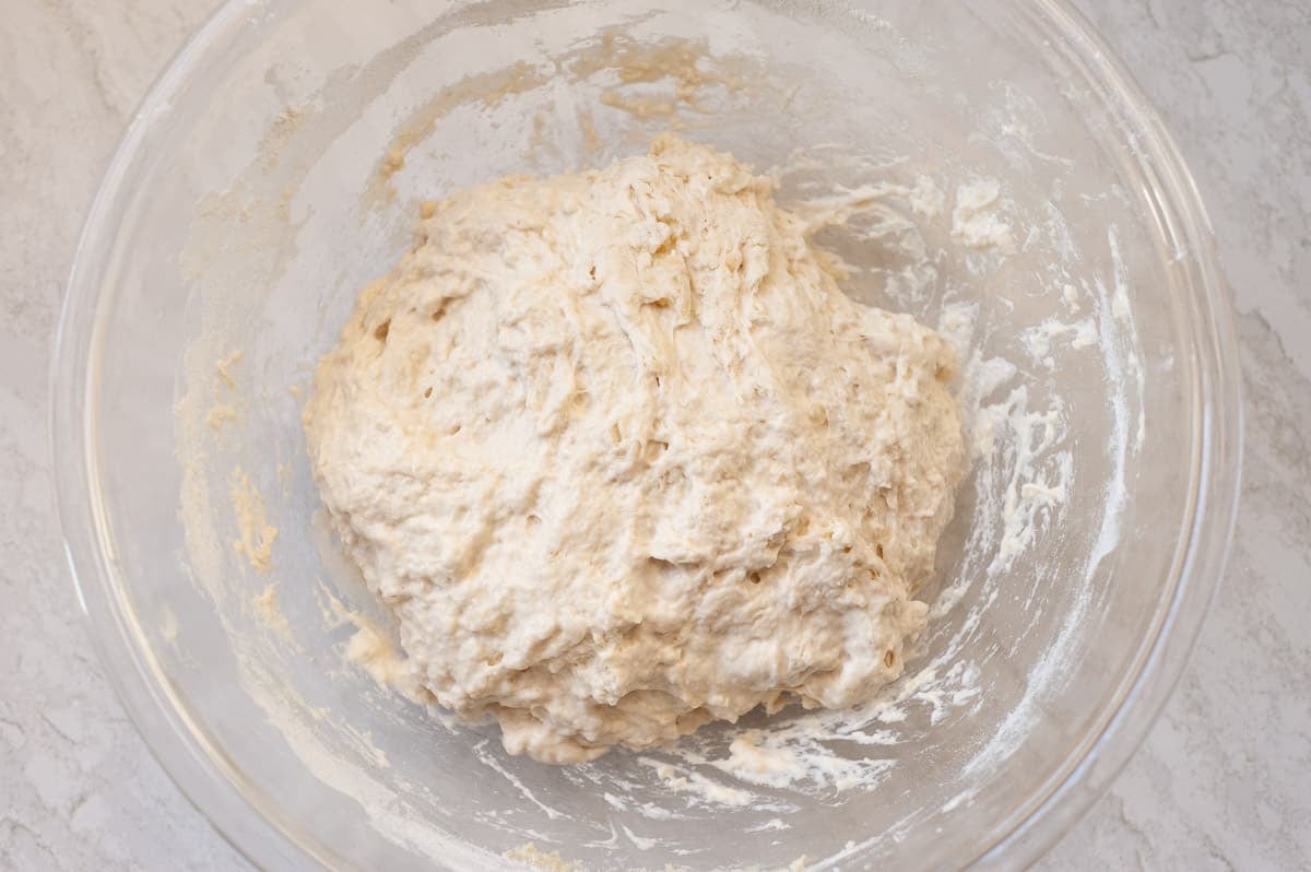 focaccia dough in a glass bowl.