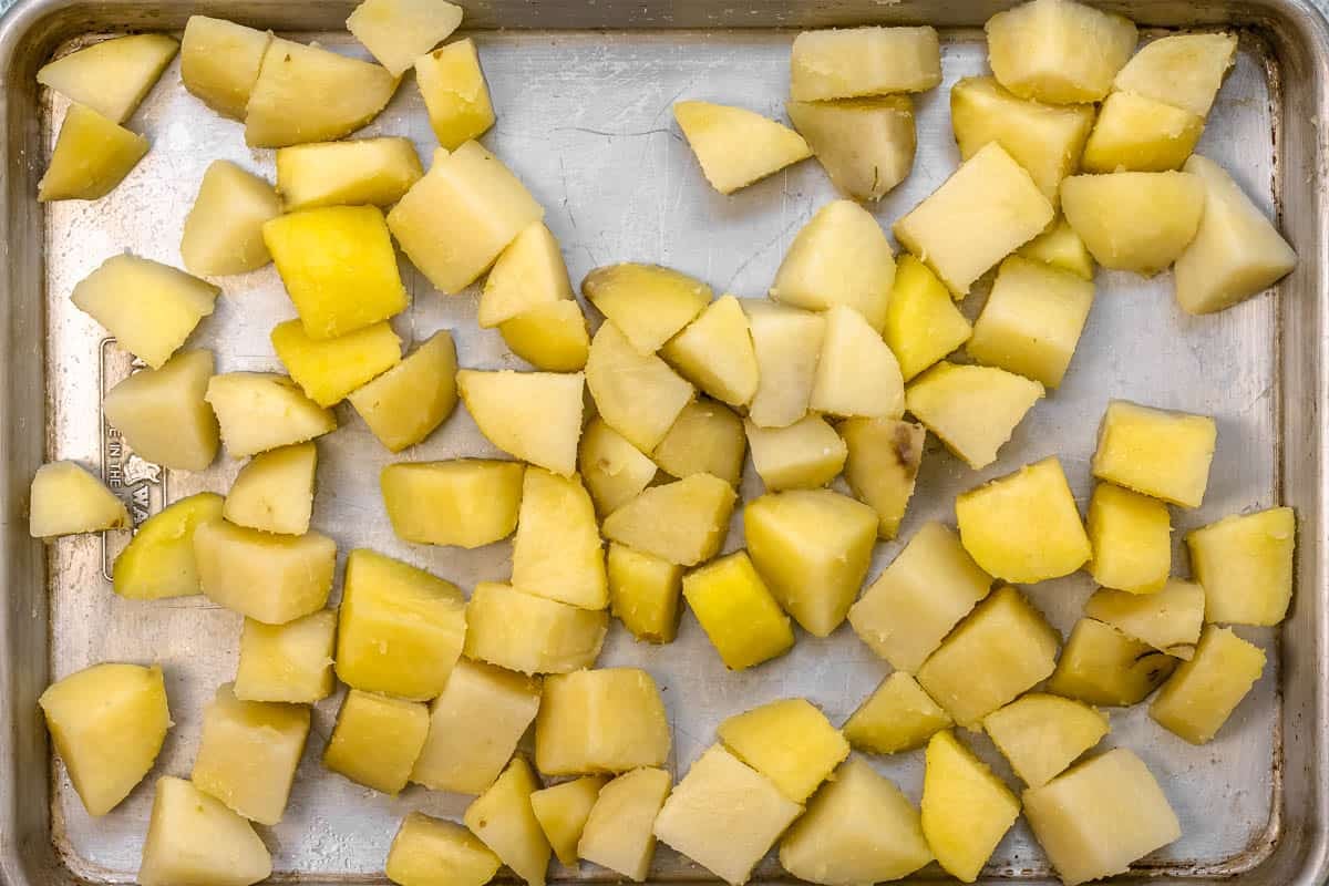 parboiled potatoes on a baking sheet with salt.