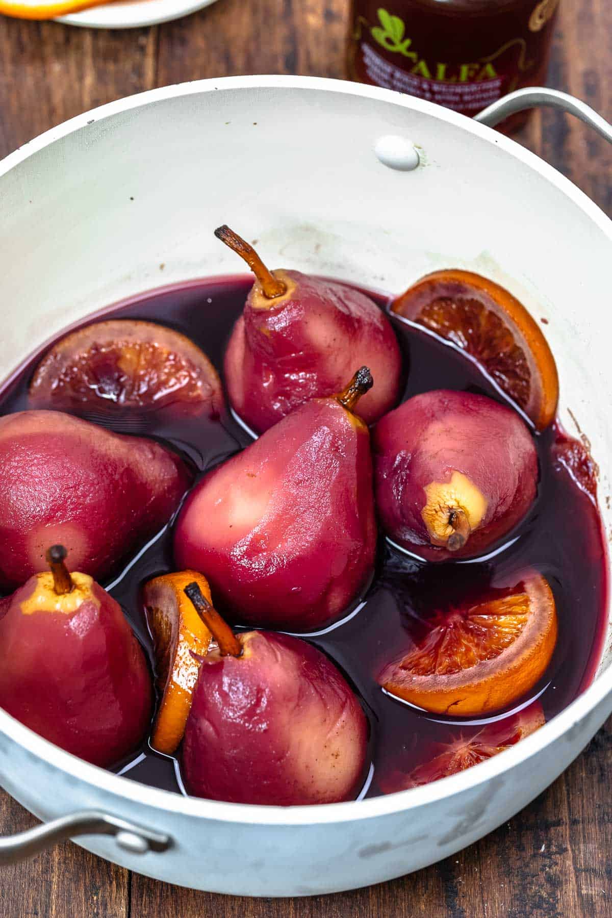 whole wine poached pears in a blue pot.