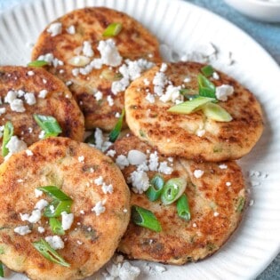 A white plate with multiple potato pancakes.