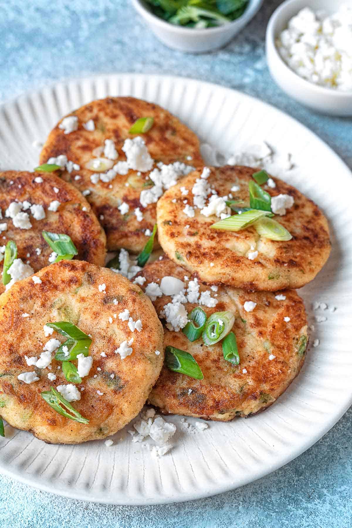 A white plate with multiple potato pancakes.