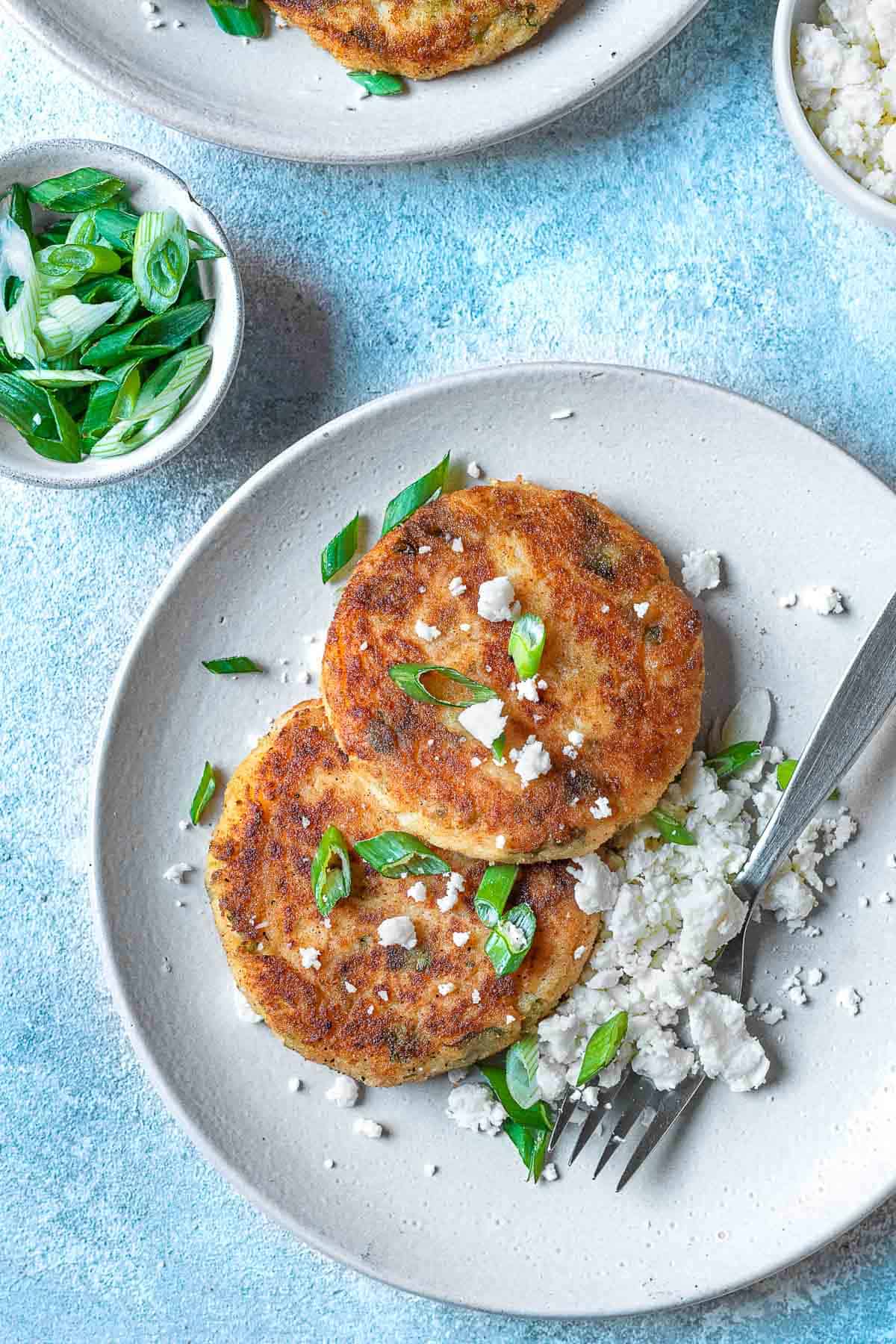 A plate with two mashed potato pancakes.