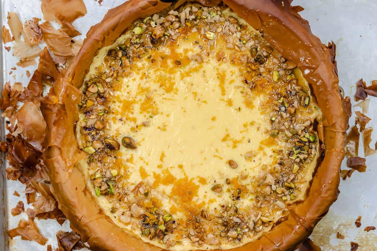 a close up of a whole baklava cheesecake with nuts on top.