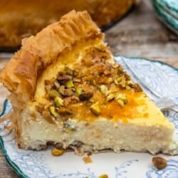a slice of baklava cheesecake on a plate with a fork.