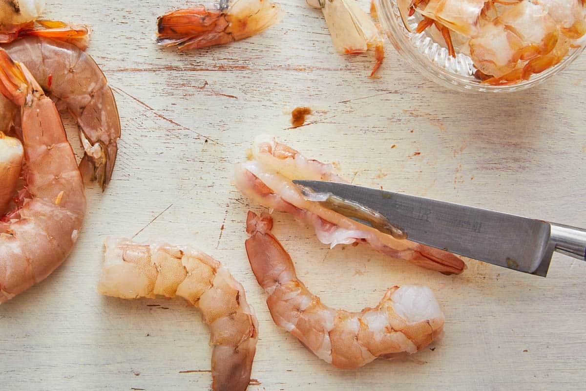 shrimp being deveined with a knife.