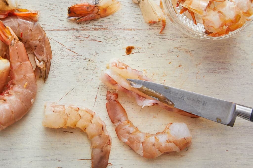 Pink shrimp deveined on counter. 