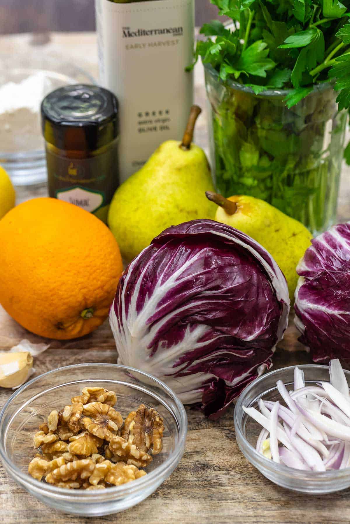 ingredients for radicchio salad including radicchio, oranges, pears, walnuts, shallots, parsley, olive oil and sumac.