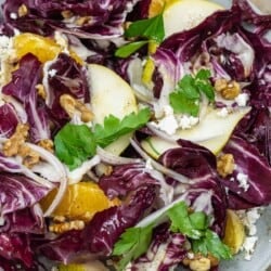 close up of radicchio salad with pears, oranges shallots, walnuts and feta cheese.