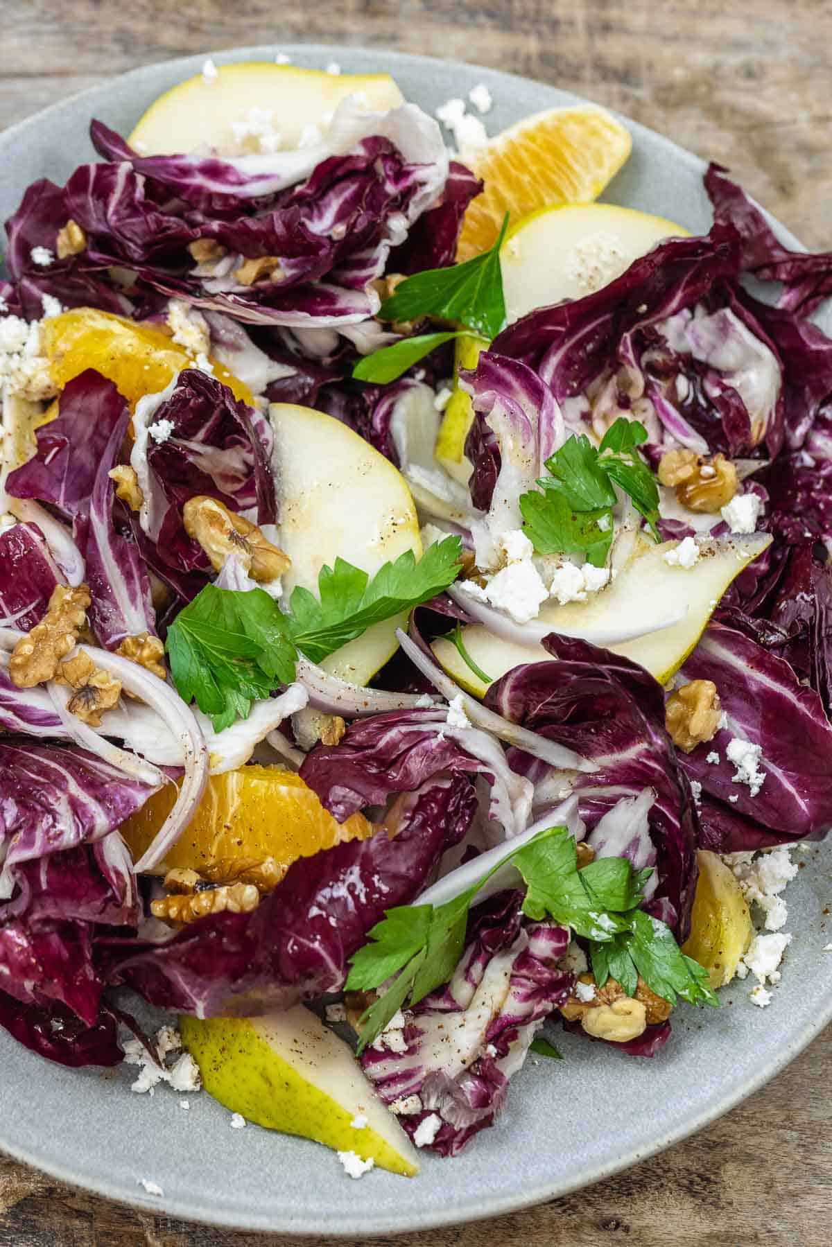 close up of radicchio salad with pears, oranges shallots, walnuts and feta cheese.