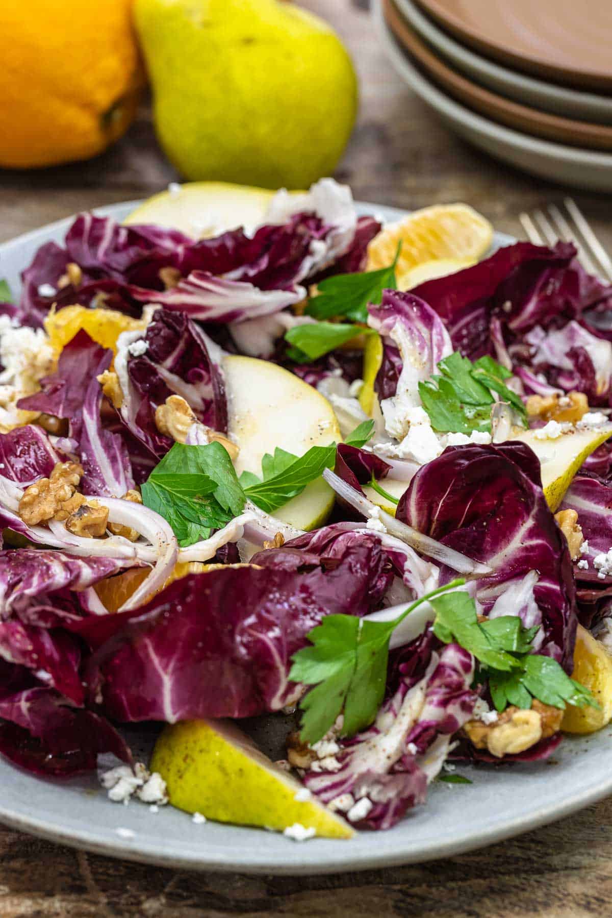 a plate of radicchio salad with and orange and pear.