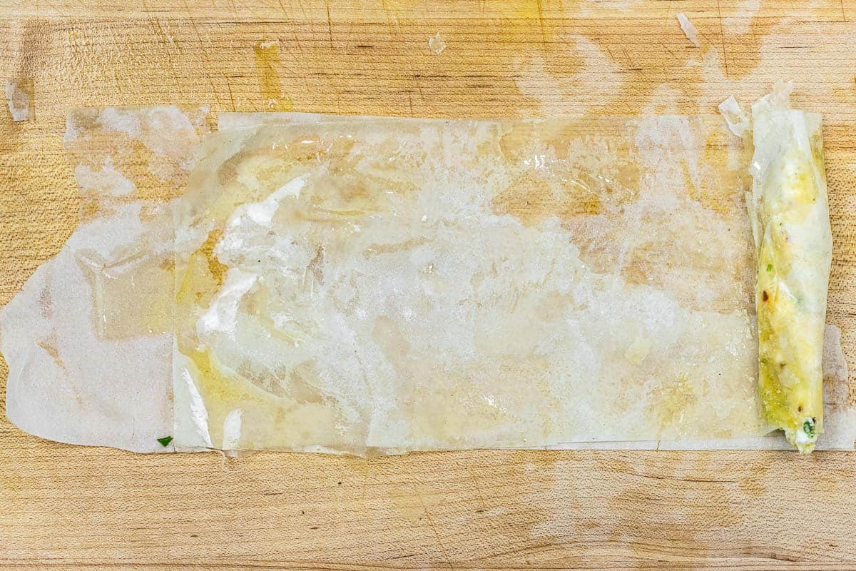sigara boregi filling being rolled in phyllo dough.
