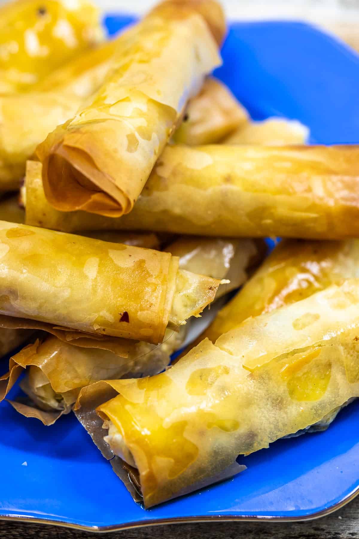 close up of sigara boregi rolls on a blue plate.